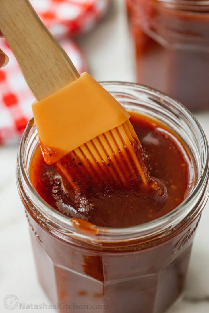Not only is this homemade Barbecue sauce the best you'll ever have, it's also much cheaper than buying it at the store. So easy to make, too! Silicone brush dipping into jar of homemade barbecue sauce