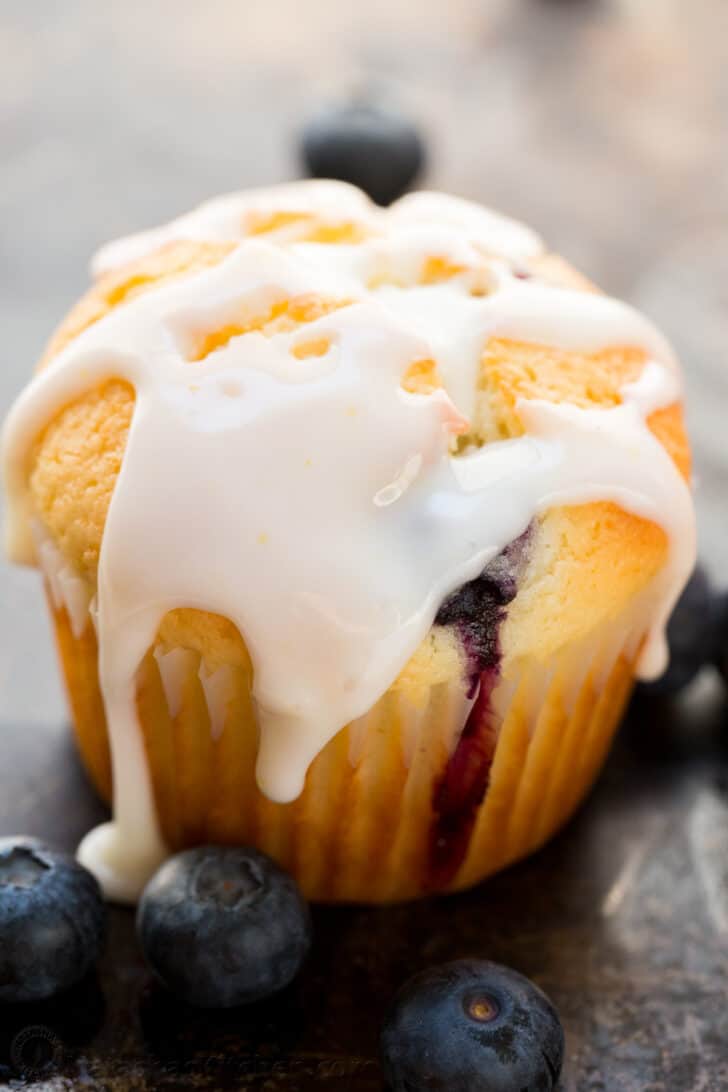 These Blueberry Muffins are bursting with juicy blueberries. They have a soft and moist crumb and puff up perfectly. The lemon glaze makes them completely irresistible and they always disappear fast! Blueberry muffin covered in lemon glaze