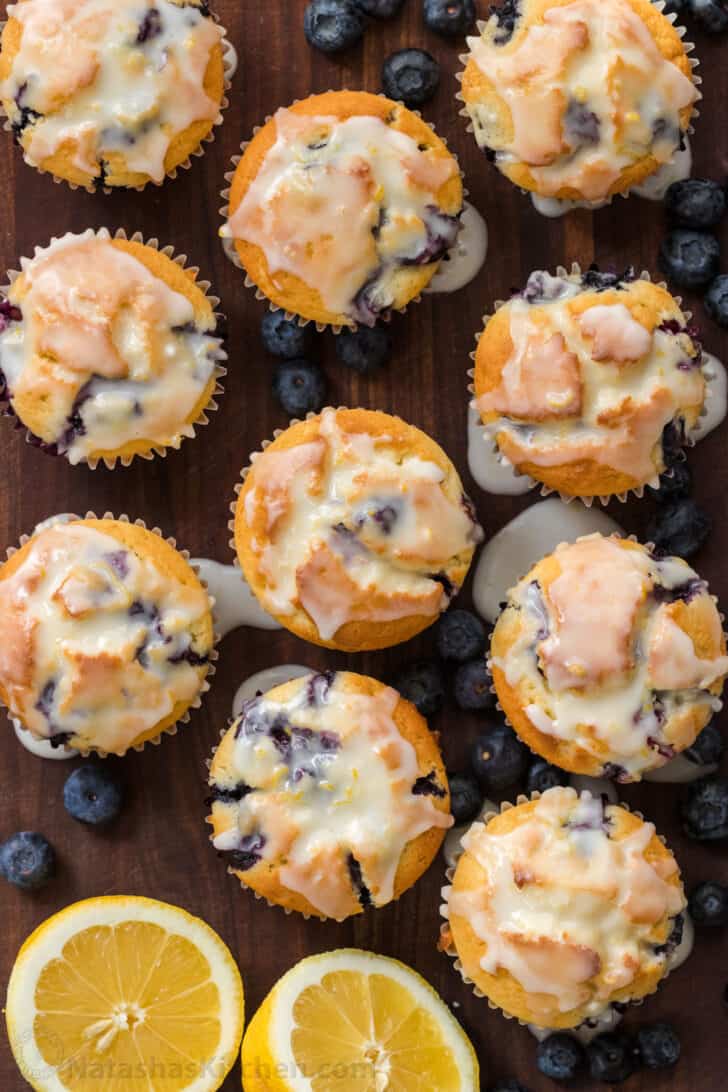 These lemon blueberry muffins are bursting with fresh blueberry flavor. This blueberry muffin recipe has a soft and moist crumb and they puff up perfectly. The easy lemon glaze recipe makes them completely irresistible and they always disappear fast! | natashaskitchen.com glazed blueberry muffins