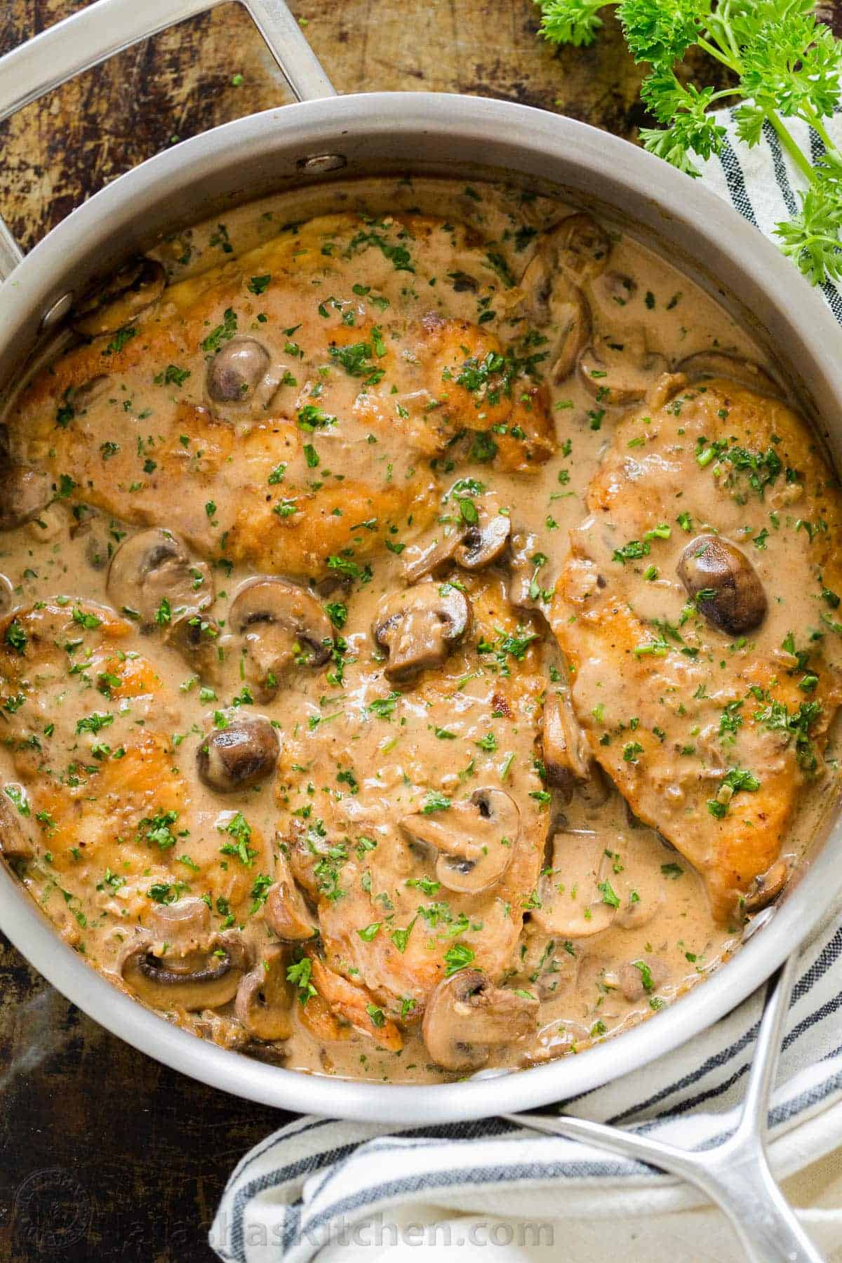 This classic Italian Chicken Marsala is an easy 30-minute chicken dinner. Juicy pan-seared chicken in a creamy mushroom marsala wine sauce. Chicken Marsala topped with parsley and mushrooms in a pan.