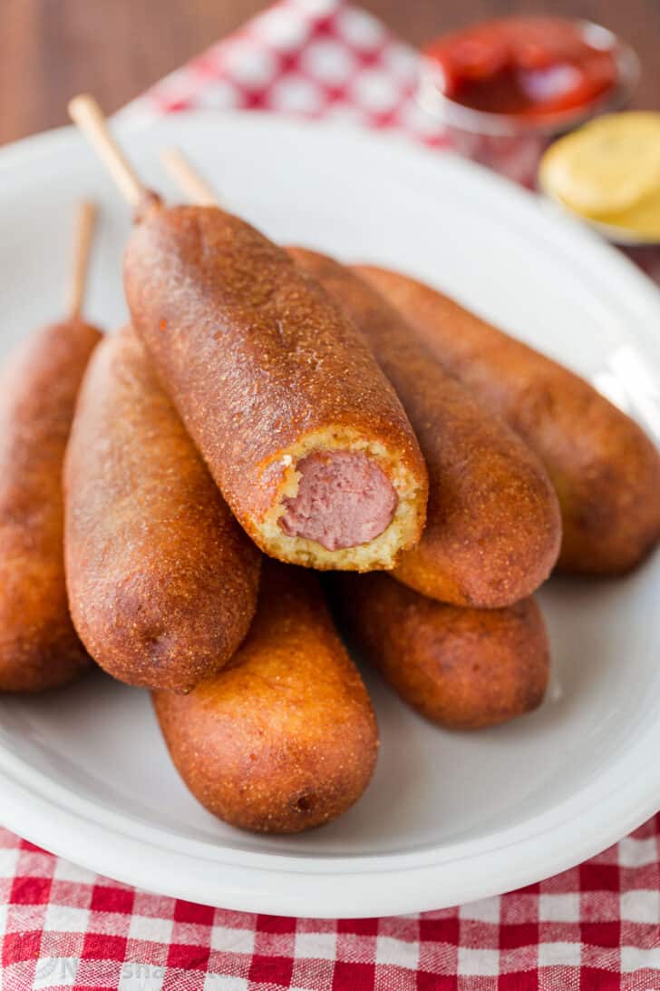 Honey-battered, hand-dipped Corn Dogs are a real treat. Watch the video tutorial and see how easy it is to make homemade corn dogs from scratch. corn dogs on a platter served