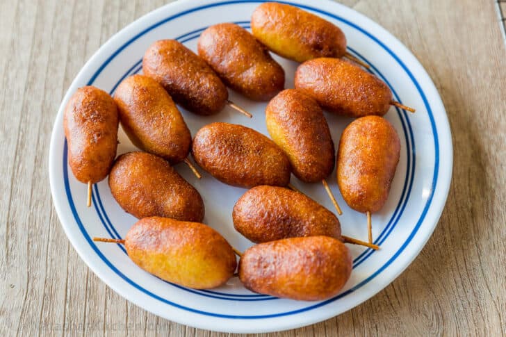 Honey-battered, hand-dipped Corn Dogs are a real treat. Watch the video tutorial and see how easy it is to make homemade corn dogs from scratch. mini corn dogs on a plate