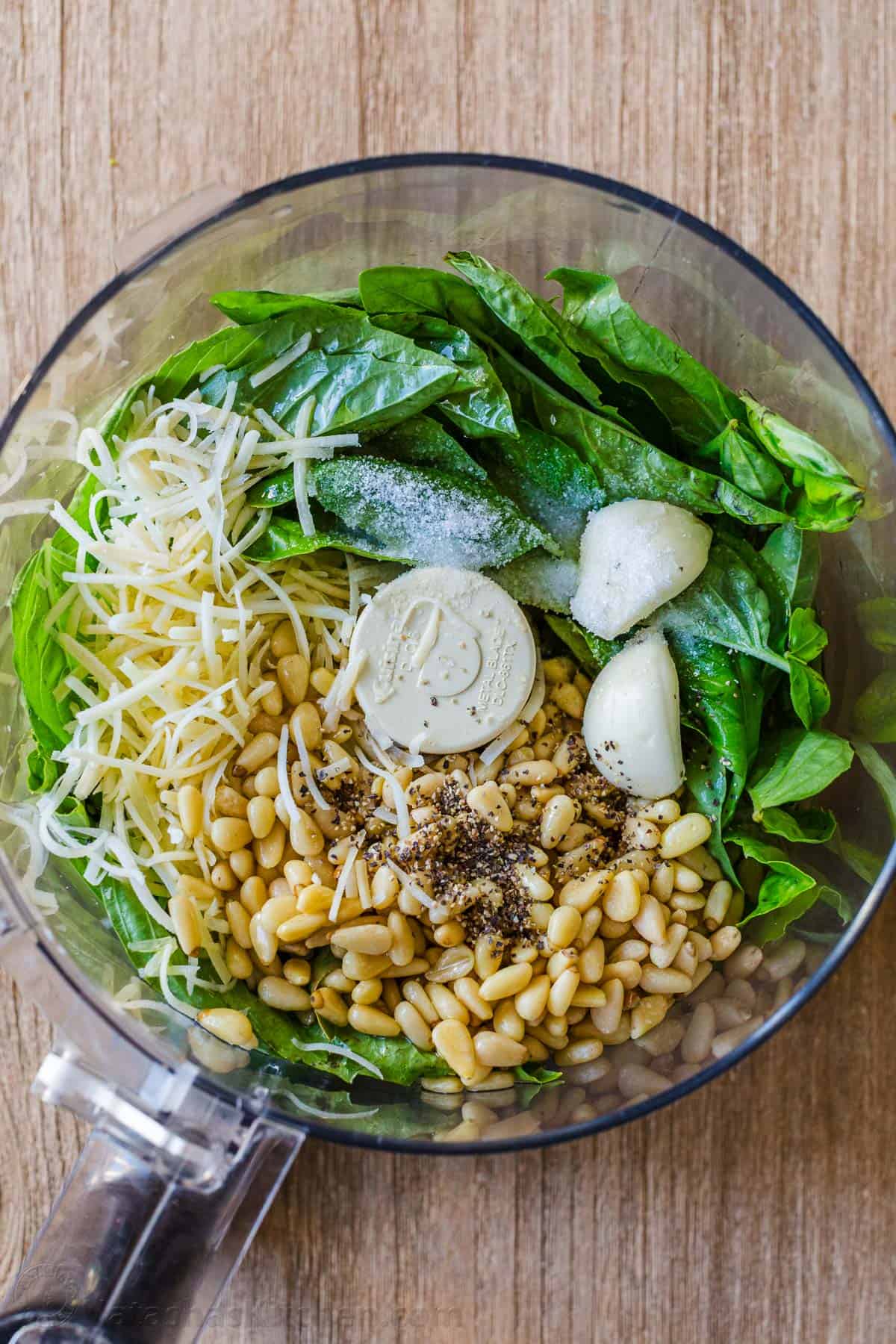 This homemade pesto tastes way better than storebought. Basil pesto is easy to make and so versatile as a sauce, dip, spread, and topping. Ingredients for basil pesto sauce in a food processor.