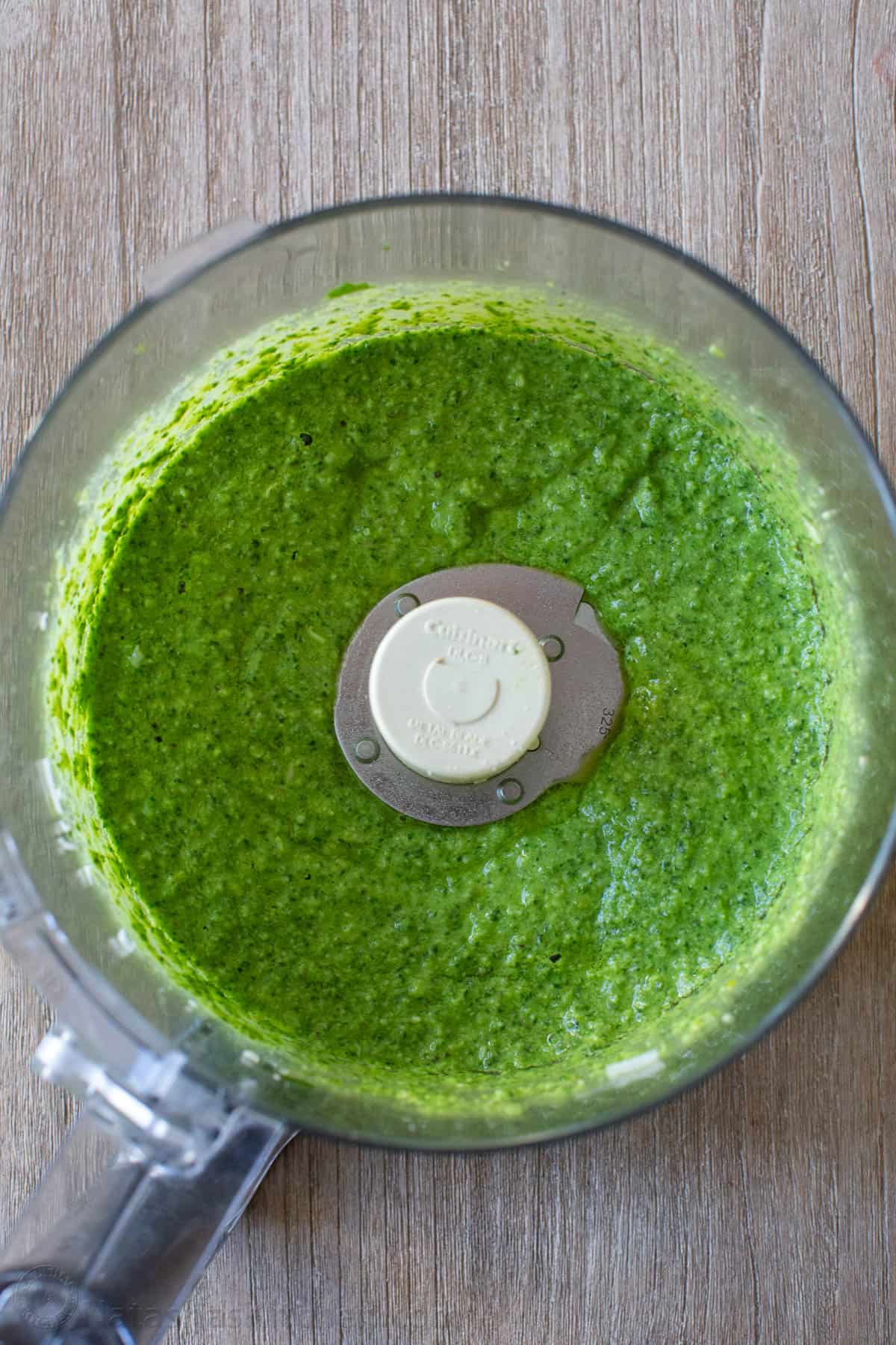 This homemade pesto tastes way better than storebought. Basil pesto is easy to make and so versatile as a sauce, dip, spread, and topping. Blended pesto sauce in a food processor bowl