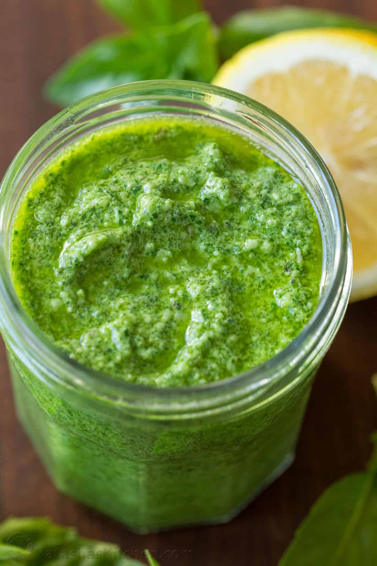 This homemade pesto tastes way better than storebought. Basil pesto is easy to make and so versatile as a sauce, dip, spread, and topping. Basil pesto in a mason jar with basil and lemon in background