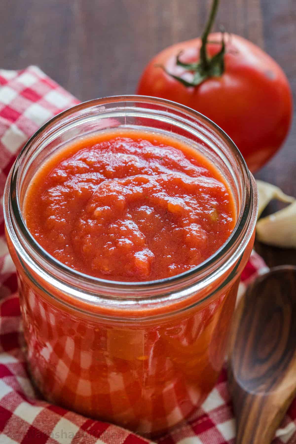 This easy pizza sauce makes for the most authentic homemade pizza. Red sauce for pizza takes just 5 minutes and 5 ingredients. No cooking! Homemade Red Sauce for Pizza in mason jar with tomatoes in the background