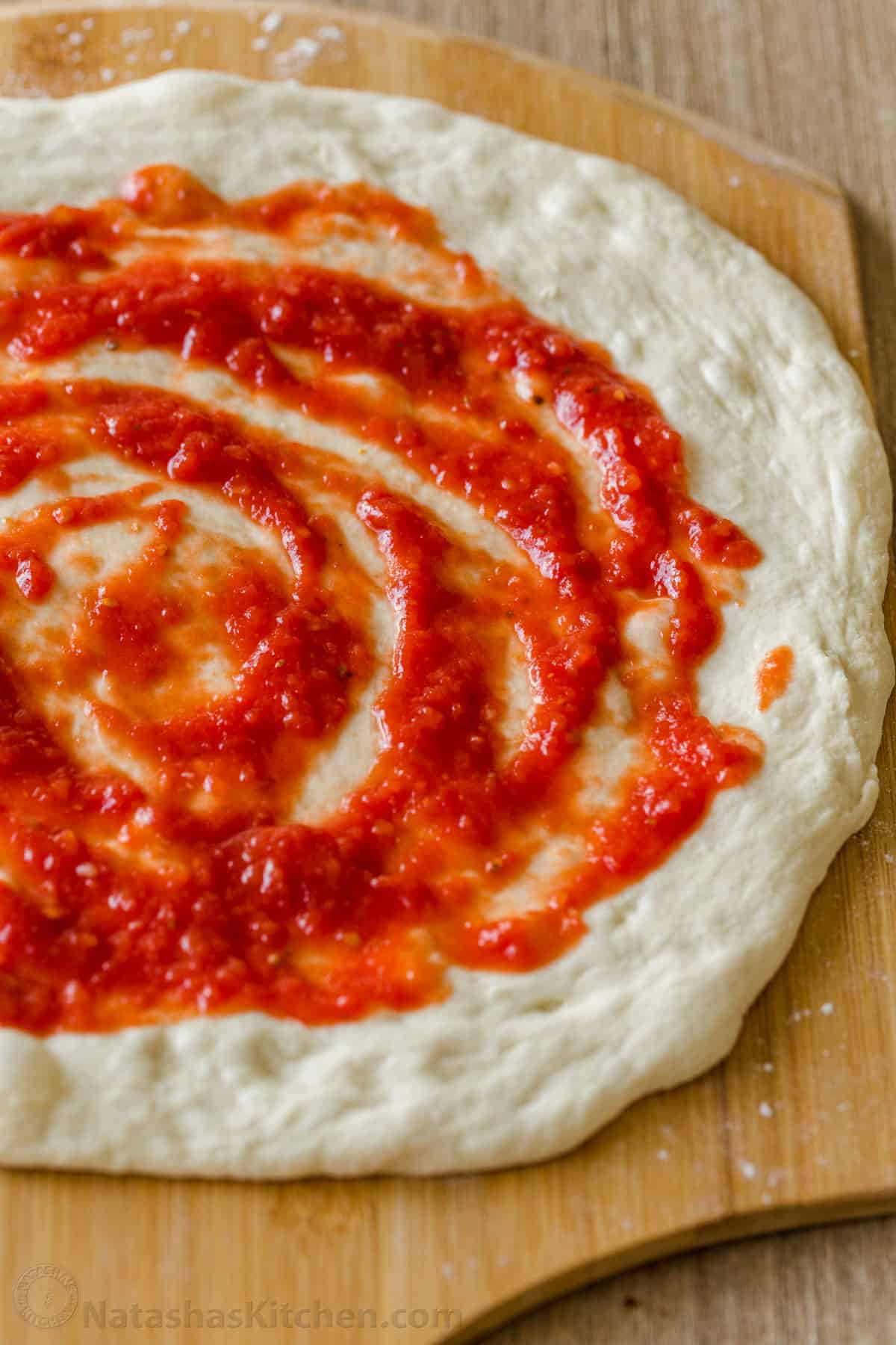 This easy pizza sauce makes for the most authentic homemade pizza. Red sauce for pizza takes just 5 minutes and 5 ingredients. No cooking! Homeamde Red Pizza Sauce swirled on pizza dough