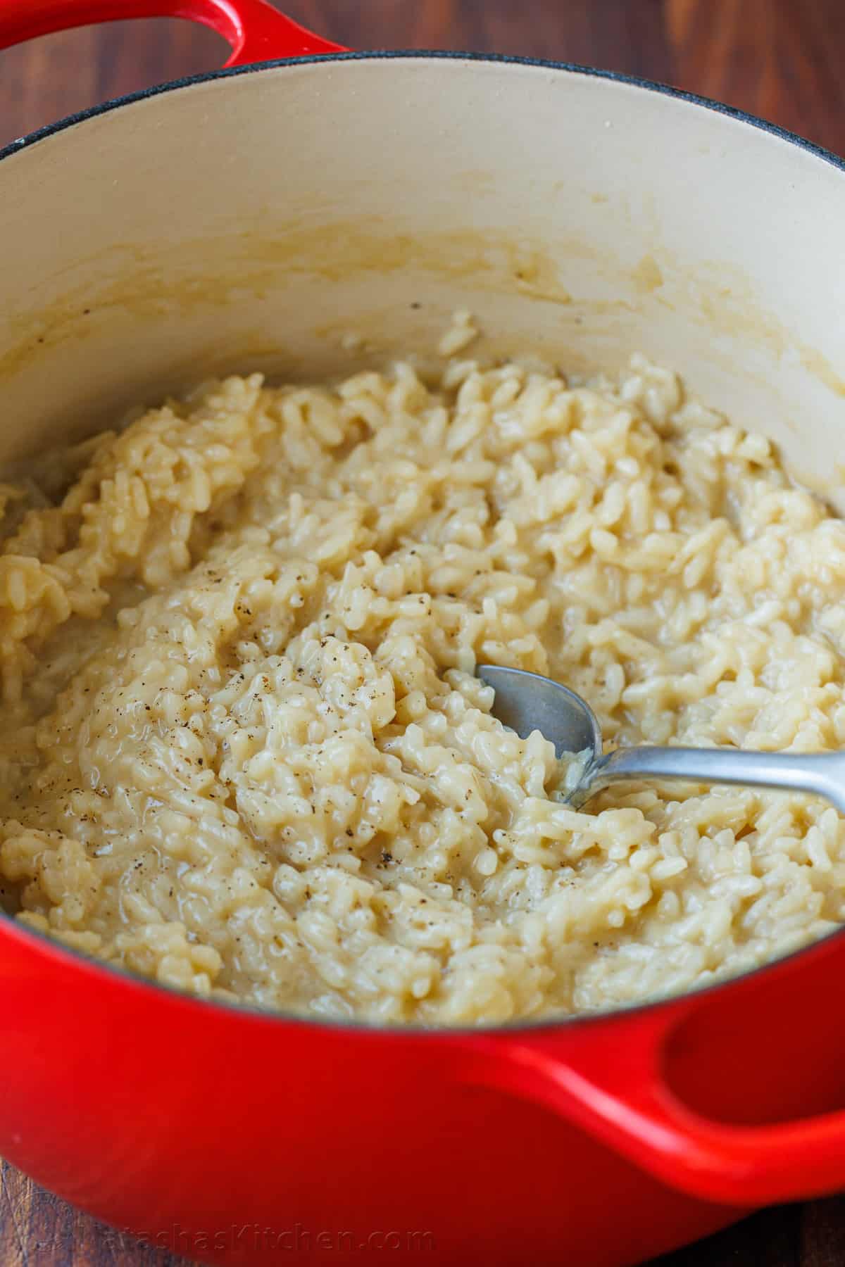 Creamy Parmesan Risotto is the ultimate Italian side dish. Learn how to make the best Risotto that can be modified in so many different ways. Cooked risotto in a red dutch oven pot