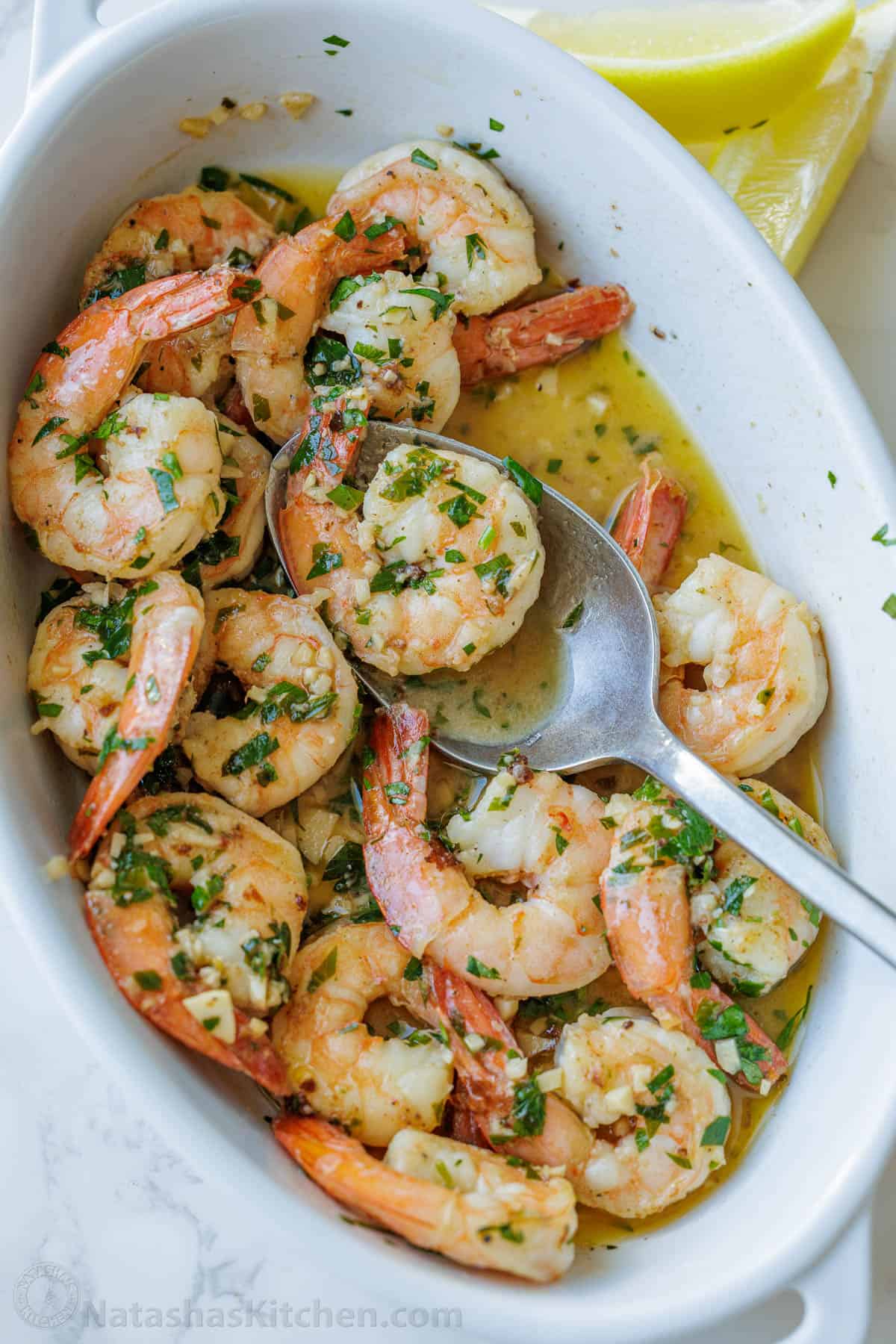 Shrimp Scampi Recipe with garlic, butter, and wine sauce drizzled with fresh lemon juice. This easy shrimp scampi takes just 10 minutes! Shrimp scampi recipe in a white dish with butter garlic sauce and parsley garnish