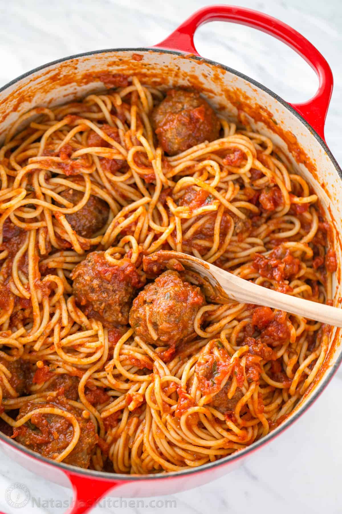 The best Spaghetti and Meatballs recipe, with big juicy meatballs and spaghetti in a homemade marinara sauce for an easy weeknight dinner. Spaghetti and Meatballs tossed together with sauce in a red dutch oven pot.