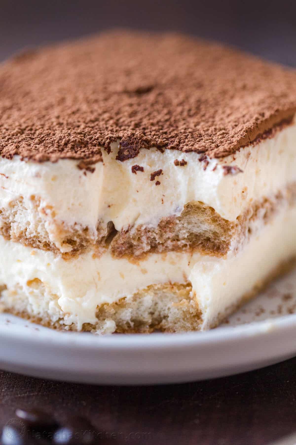 The best Classic Italian Tiramisu recipe with layers of coffee-soaked ladyfingers & decadent cream is so easy! Try my no-bake dessert recipe! homemade tiramisu recipe in a white dish with mascarpone cream layers and ladyfingers soaked in coffee