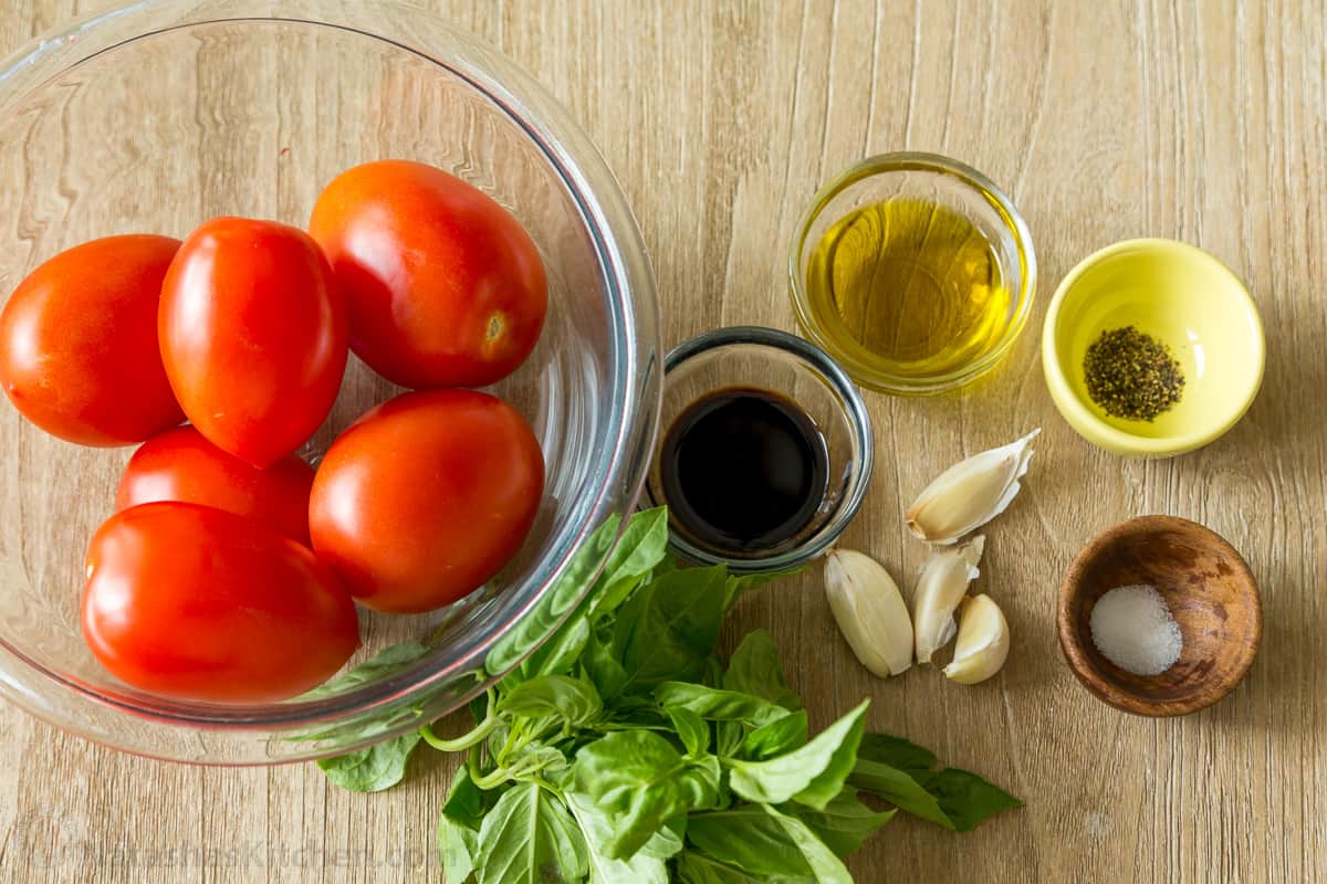 Authentic Italian Bruschetta! Learn how to make a crowd-pleasing tomato bruschetta. The parmesan toasts and drizzle of balsamic make these irresistible. Ingredients for tomato bruschetta with roma tomatoes, basil, oil, balsamic, salt and pepper